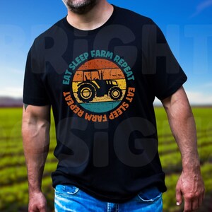 May include: A black t-shirt with a vintage-style graphic of a tractor and the text "Eat Sleep Farm Repeat" in a circle.