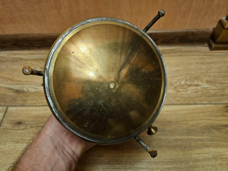 K&ouml;nnte beinhalten: Eine Schale aus Messing mit einer runden, konkaven Oberseite und drei Beinen. Die Schale ist aus gl&auml;nzendem, poliertem Messing und hat eine leicht gealterte Patina.