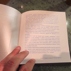 Pu&ograve; includere: Un libro aperto con una copertina bianca e testo blu. Il testo dice "Questo &egrave; il libro che ti aiuter&agrave; a trovare la tua strada nel mondo." Il libro &egrave; aperto a una pagina con uno sfondo blu e testo bianco. Il testo &egrave; in una lingua straniera.