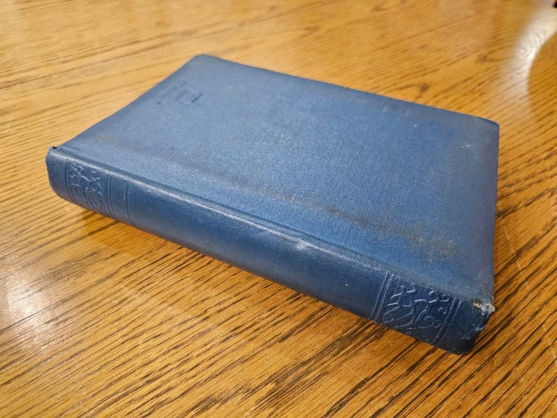 May include: A blue hardcover book with a decorative design on the spine.