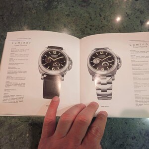 Pu&ograve; includere: Due orologi da polso con quadrante nero, dettagli argentati e cinturini in pelle nera. L'orologio a sinistra ha un cinturino in pelle nera e l'orologio a destra ha un cinturino in metallo argentato. Entrambi gli orologi hanno la scritta "Luminor" stampata sul quadrante.