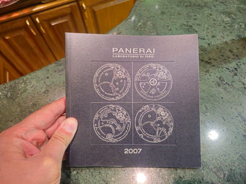 Pu&ograve; includere: Brochure in bianco e nero con il testo "PANERAI LABORATORIO DI IDEE" e l'anno "2007". La brochure presenta quattro illustrazioni dettagliate di meccanismi di orologi.