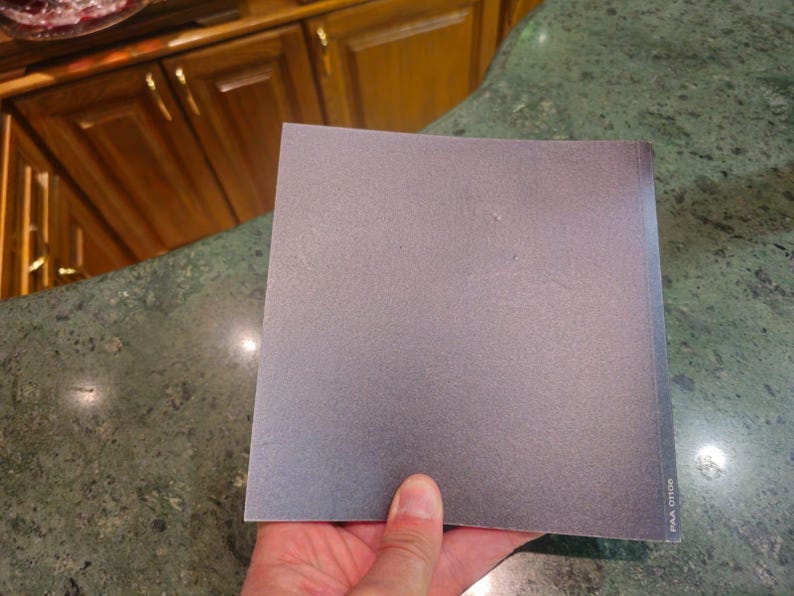 Pu&ograve; includere: Un foglio di carta vetrata grigia con il testo "P400 07109" stampato sul lato.