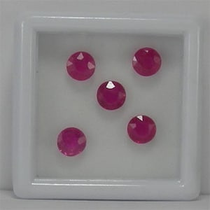 Peut inclure: Cinq pierres précieuses rondes de couleur rose dans un écrin carré blanc.