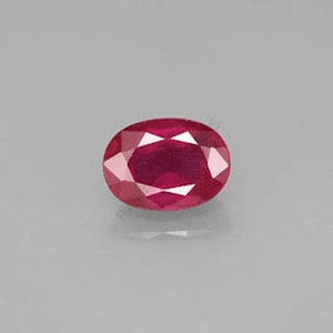 Può includere: Una gemma ovale di colore rosso vibrante con una finitura lucida.