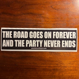 May include: Black and white sticker with the text "THE ROAD GOES ON FOREVER AND THE PARTY NEVER ENDS" and the website "psychocowboys.com" printed below.