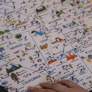 Close-up of Western USA travel map with push pins marking landmarks in Nevada, California, Utah, and Colorado. Interactive, customizable travel map with national parks, perfect for documenting adventures and decorating your home