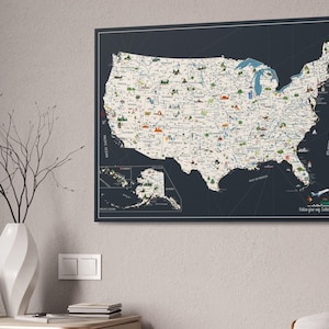 USA Travel Map, illustrated with top attractions for each state, hanged on a wall. The USA map is printed on canvas, the background is charcoal, while the land is light beige. In the right corner of the USA Map it is a personalization.