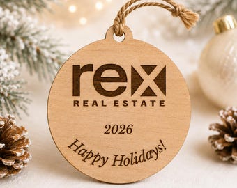 以下が含まれることがあります： レーザー刻印で「rex REAL ESTATE」、年号「2026」、そして「Happy Holidays!」というダークブラウンの文字が施された、明るい色の丸い木製オーナメント。吊り下げ用のナチュラルなジュート麻紐のループが付いています。