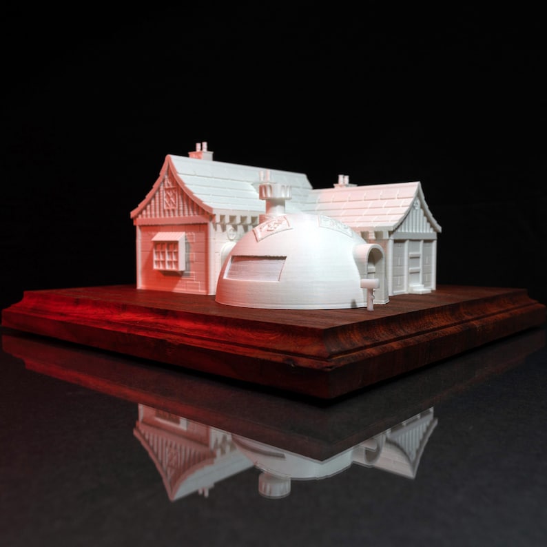 May include: A white 3D printed model of a house with a dome-shaped roof. The house is sitting on a wooden base.
