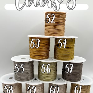 Puede incluir: Imagen de diez carretes de cord&oacute;n en varios tonos de marr&oacute;n, beige y verde oliva. Cada carrete est&aacute; etiquetado con un n&uacute;mero del 52 al 61. El texto "Colors 5" est&aacute; escrito en cursiva en la parte superior de la imagen.