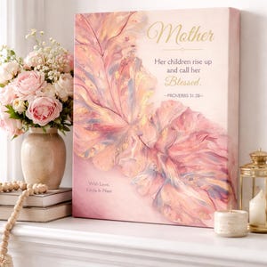 May include: A pink canvas print with the word "Mother" in gold script. The print features a floral design in shades of pink and peach, with the text "Her children rise up and call her Blessed." A vase of pink roses sits nearby.