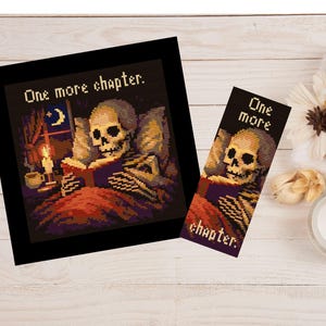 May include: A framed cross-stitch depicting a skeleton reading in bed with a candle and the text "One more chapter." A matching bookmark shows the same image. The colour palette includes black, red, and yellow.