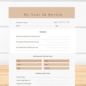 May include: A printable year in review worksheet with sections for highlights, favorite memories, and goals for the next year. The worksheet has a beige background and black text.