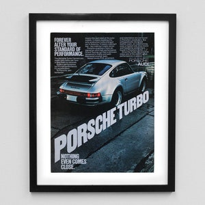 May include: A vintage print advertisement for the Porsche Turbo car. The ad features a silver Porsche Turbo car on a black and white asphalt road. The text reads "Forever alter your standard of performance. Porsche Turbo. Nothing even comes close."