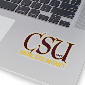 May include: A white sticker with the text "CSU CENTRAL STATE UNIVERSITY 1887" in maroon and gold lettering. The sticker is on a silver laptop.