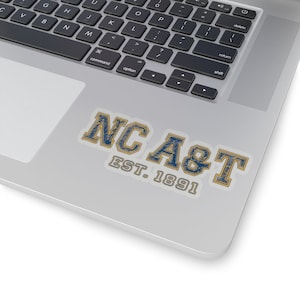 May include: A blue and gold sticker with the text "NC A&T EST. 1891" on a silver laptop.