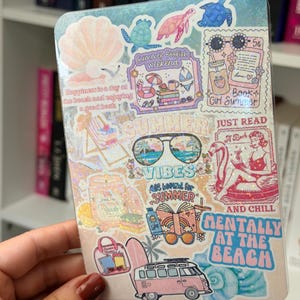 May include: A rectangular holographic sticker sheet featuring various summer and book-themed illustrations, including a seashell, sea turtles, sunglasses, a pink van, and text such as "Summer Bookish weekend," "Book Girl Summer," "Summer Vibes," and "Mentally at the beach."
