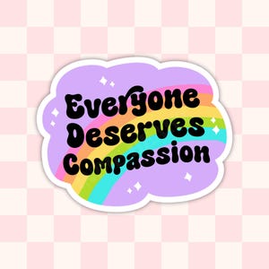 May include: A sticker with a rainbow and the text "Everyone Deserves Compassion" in a retro font.