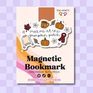May include: A magnetic bookmark on a display card featuring the text "meet me at the pumpkin patch" surrounded by illustrations of a sweater, pumpkins, a mug, leaves, flowers, and a scarf. The card includes the text "Magnetic Bookmark", "HANDMADE IN FLORIDA", and "@INDIEHEARTSTUDIO".