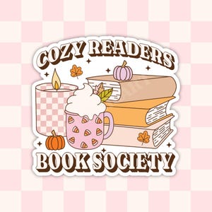 May include: A sticker with a retro design featuring the text "Cozy Readers Book Society". The sticker includes illustrations of a stack of books, a mug of hot chocolate with whipped cream, a candle, and pumpkins.