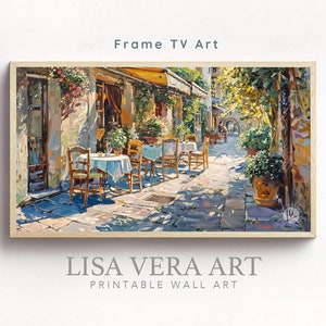 May include: A painting of a sunny, outdoor cafe scene in a European city. The cafe has tables and chairs set up on a cobblestone street, with a building and greenery in the background. The painting is framed in a light wood frame.