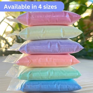 May include: Six pastel-coloured pouches stacked on top of each other. Each sealed pouch is a different colour: pink, yellow, purple, peach, green, and blue. The text "Available in 4 sizes" is in a blue rectangle at the top.
