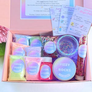 May include: A pink box filled with a magic potion kit. The kit includes bags of magic dust, a bottle of magic liquid, a container of fizzy rocks, and a tube of magic glitter. Instructions are included.