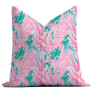 May include: Pink throw pillow with a coral reef pattern in shades of pink, blue, and green.