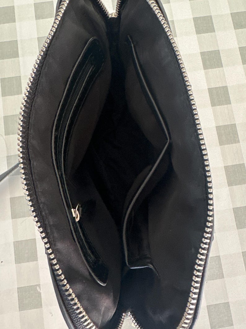 May include: Black leather crossbody bag with a zipper closure and two interior pockets.