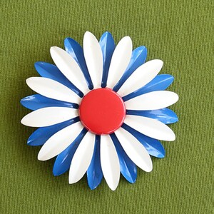 Retro colorful 60s metal flower brooch is large blue and white daisy with red center.