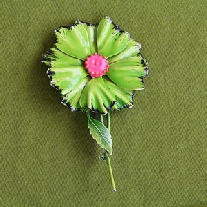 Retro 60s colorful metal flower brooch is large bright green with black edges, pink center, long green stem and one green leaf.