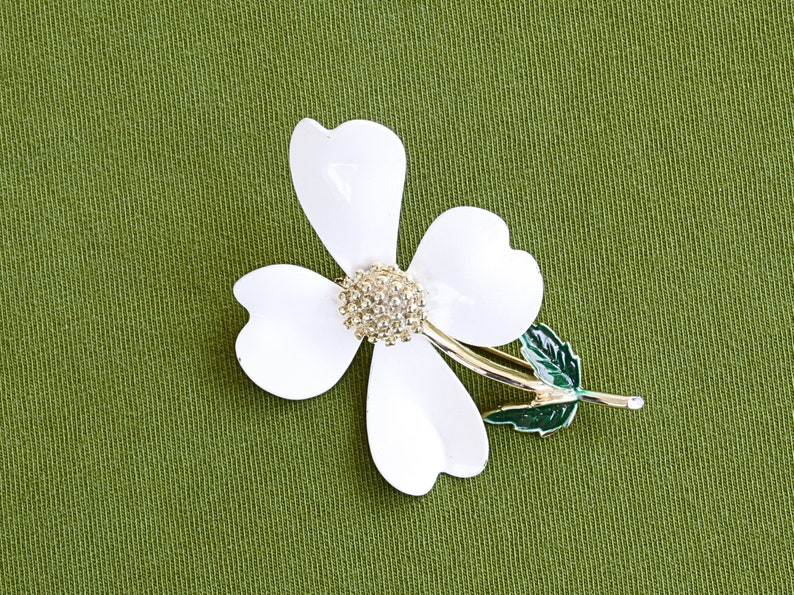 Retro 60s colorful metal flower brooch is a white dogwood with silver center and green leaves, marked Sarah Coventry.