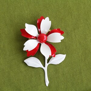 Retro 60s colorful metal flower brooch is red and white pinwheel with red center, and white stem and leaves.