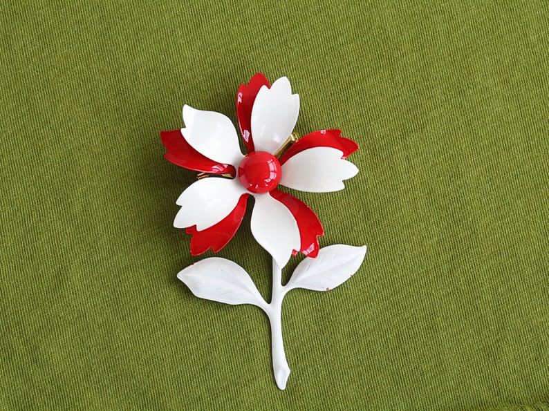 Retro 60s colorful metal flower brooch is red and white pinwheel with red center, and white stem and leaves.