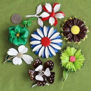 Retro colorful metal flower brooches in seven varieties with quarter for sizing.