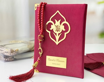 May include: A burgundy velvet book with a gold Islamic design and a red tassel. The book is personalized with the names "Navid & Mariam" and the date "29/03/2022".