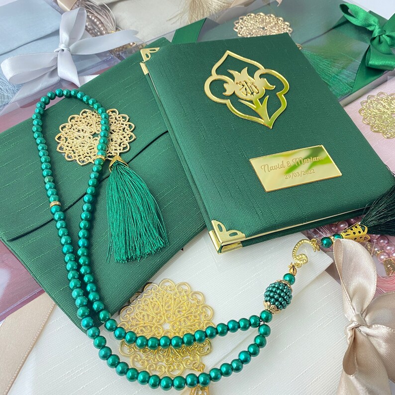 Pu&ograve; includere: Un libro di preghiere verde con dettagli dorati e un design floreale. Il libro ha un'iscrizione personalizzata che recita "Navid & Maryam 29/03/2022". Il libro &egrave; accompagnato da una collana di preghiera con perline verdi e un fiocco.