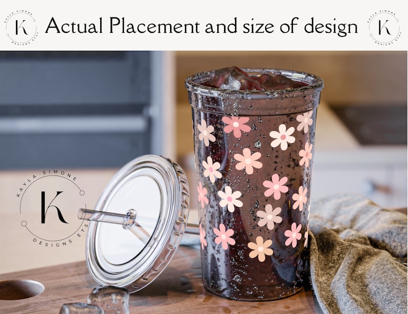 May include: A clear tumbler with a black lid and a straw. The tumbler is decorated with pink and peach flowers. The tumbler is filled with a dark liquid and ice.