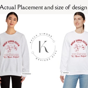 K&ouml;nnte beinhalten: Zwei wei&szlig;e Sweatshirts mit einem roten Grafikdesign, auf dem "Self Love Club" mit einem Amor und einem Herzen steht. Der Pullover links ist &uuml;berdimensioniert und der Pullover rechts ist figurbetont.