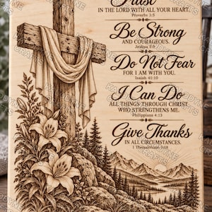May include: A rectangular light-coloured wooden plaque featuring a laser-engraved design of a wooden cross draped in fabric, lilies, and a mountain landscape. The text includes Bible verses: Trust in the Lord, Be Strong, Do Not Fear, I Can Do All Things, and Give Thanks.