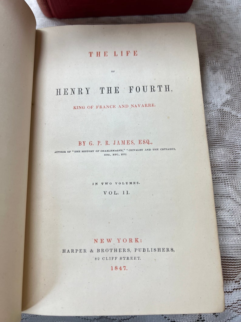K&ouml;nnte beinhalten: Offene Buchseite mit dem Titel "THE LIFE OF HENRY THE FOURTH, KING OF FRANCE AND NAVARRE." Ver&ouml;ffentlicht von Harper & Brothers, New York, 1847. Der Text ist in Schwarz und Rot auf cremefarbenem Papier gedruckt.