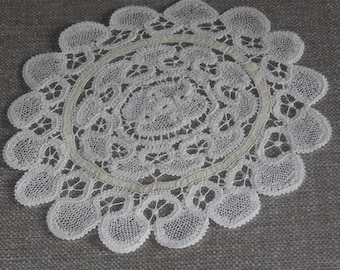 Old round lace placemat with handmade spindle