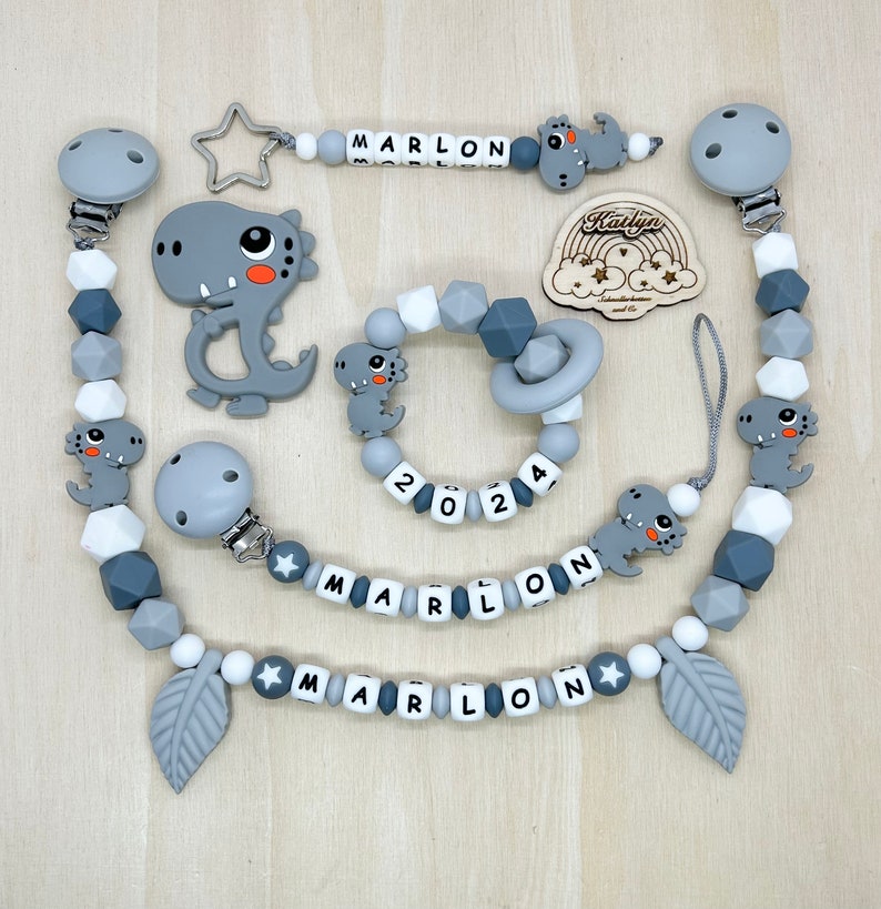Babygeschenk Schnullerkette mit Name , kinderwagenkette, schlüsselanhänger und Greifling aus silikon perlen Dino Ring adaptor gratis Komplett Set