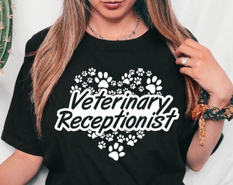 Könnte beinhalten: Schwarzes T-Shirt mit einem weißen Herzdesign mit Pfotenabdrücken und dem Text "Veterinary Receptionist".