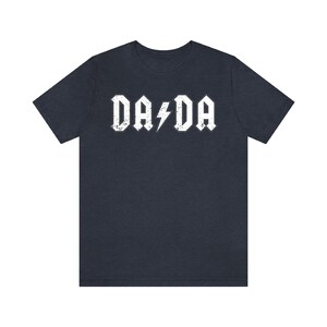 May include: A dark blue t-shirt with a white graphic that says "DA DA" with a lightning bolt in between the words.