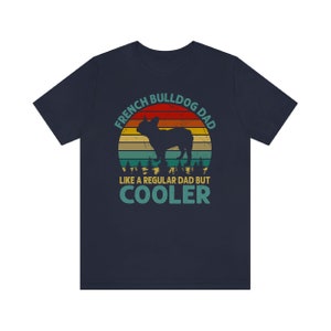 May include: Navy blue t-shirt with a vintage-style graphic of a French Bulldog. The graphic features a sunset background with the text "French Bulldog Dad Like a Regular Dad But Cooler".
