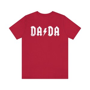 May include: Red t-shirt with a white graphic that says "DA DA" with a lightning bolt in between the words.