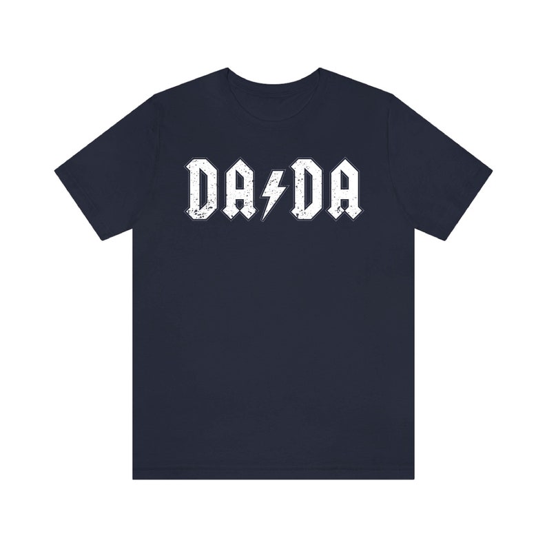 May include: A navy blue t-shirt with a white distressed graphic that says "DA DA" with a lightning bolt in between the words.