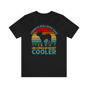 May include: Black t-shirt with a vintage-style graphic of a French Bulldog. The graphic says "French Bulldog Dad Like a Regular Dad But Cooler".